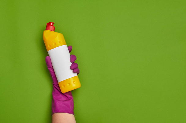 Detergentes y accesorios de limpieza sobre fondo verde. Concepto de servicio doméstico
. - Foto, imagen