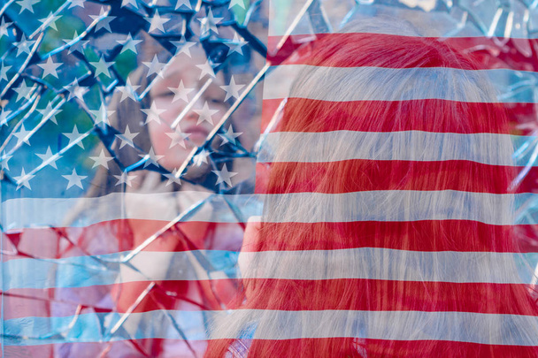 Дівчина школярка дивиться в розбитому дзеркалі і страждає на тлі американського прапора. Концепція кризи - Фото, зображення