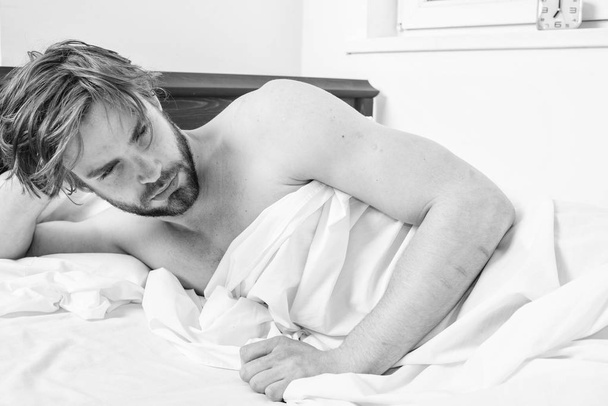 Man sleepy drowsy unshaven bearded face covered blanket having nap. Man unshaven handsome relaxing bed. Power napping may help you get through day. Have nap relax. Guy lay under white bedclothes - Foto, Imagen