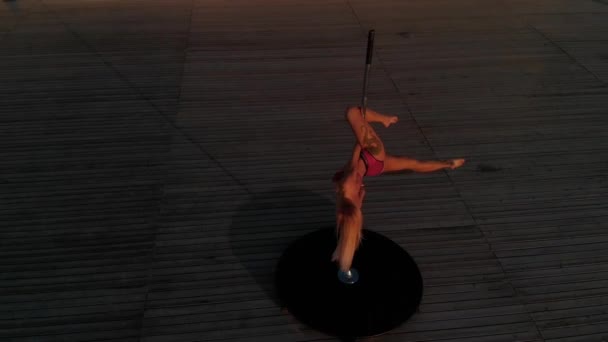 Замедленная съемка с воздуха: гибкая танцовщица на шесте в красном спортивном нижнем белье на пилоне на закате на пляже - татуировка Дракона и акробатическая гимнастика
 - Кадры, видео