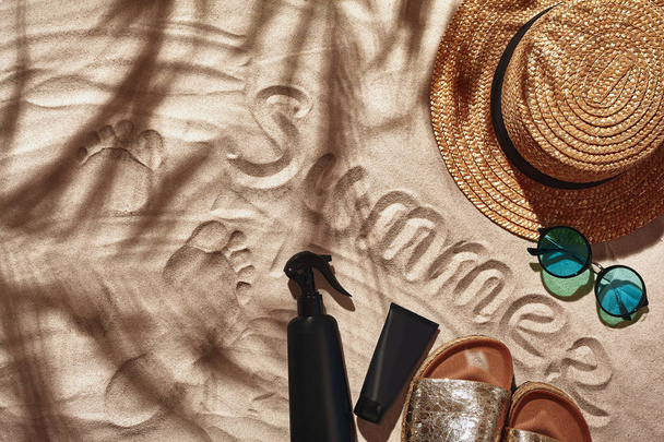 Reizigers vakantie accessoires zijn aangelegd op een wit strand zand. Vlakke lay, bovenaanzicht. - Foto, afbeelding