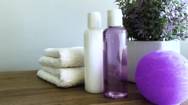 Asciugamani e gel doccia su tavolo bianco con spazio copia su sfondo bagno
. - Filmati, video