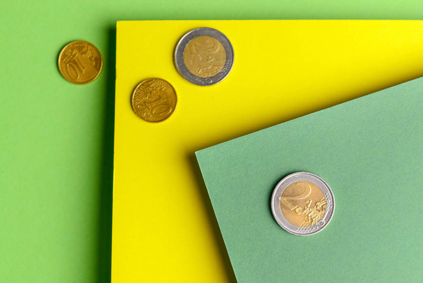 色の背景にコインを持つ紙シート - 写真・画像