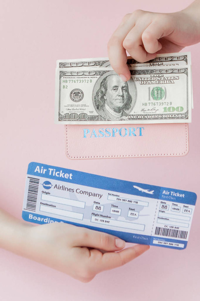 Passport, dollars and air ticket in woman hand on a pink background. Travel concept, copy space - Photo, image