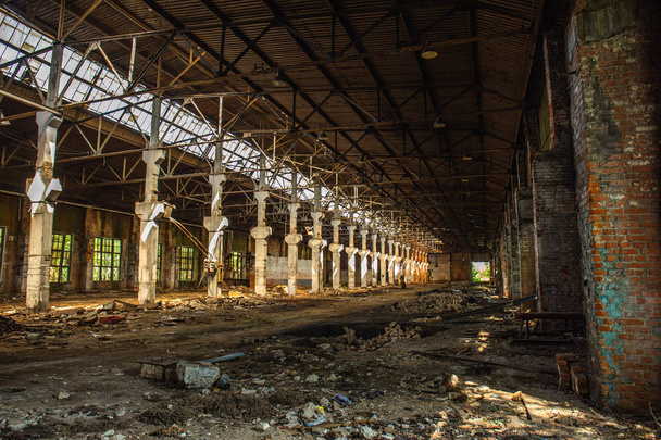 Verlaten geruïneerd industrieel magazijn of fabrieksgebouw, uitzicht op de gang met perspectief, ruïnes en sloop concept - Foto, afbeelding