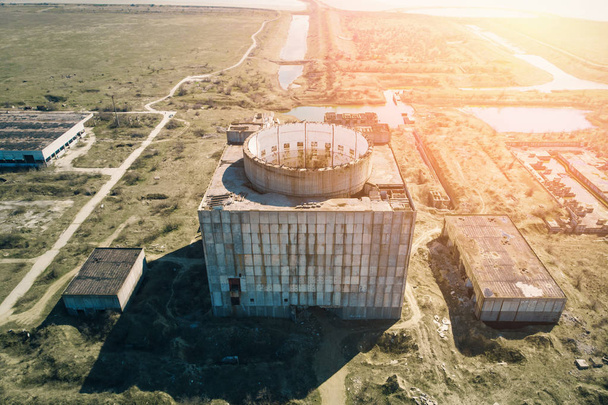 Verlaten en verwoeste kerncentrale in Shelkino, de Krim. Industriële constructie met ronde toren van atoom reactor, luchtfoto, Drone schot - Foto, afbeelding