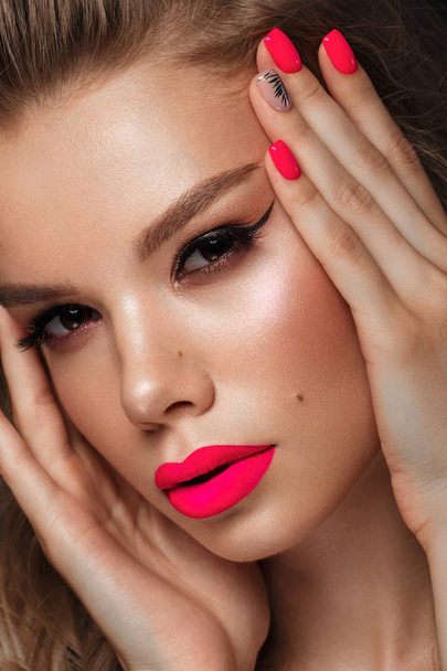 Beautiful young woman with bright makeup and neon pink nails. Beauty face. Photo taken in the studio - Foto, Bild