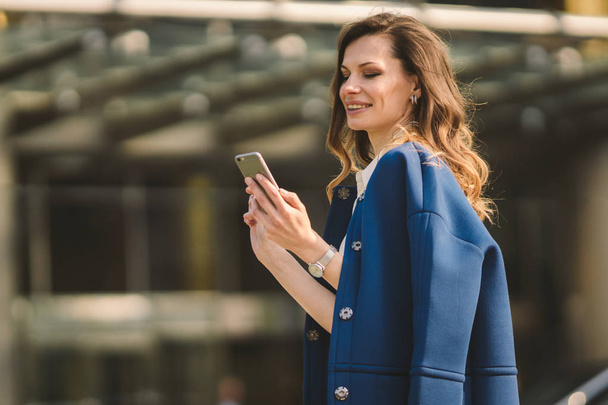 Office buildings city people in suit. Caucasian businesswoman using smartphone with hand. Business concept. Portrait stylish business woman in fashionable clothes holding Phone near office building - Foto, immagini
