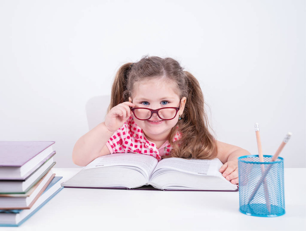  smiling blond little cute girl studying on books - Φωτογραφία, εικόνα