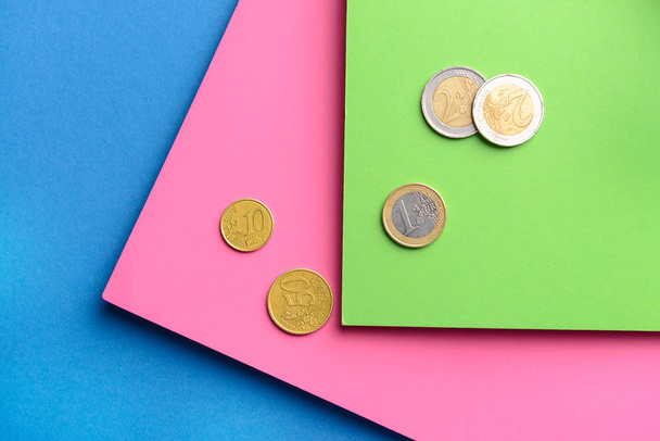 Бумажные листы с монетами на цветном фоне
 - Фото, изображение