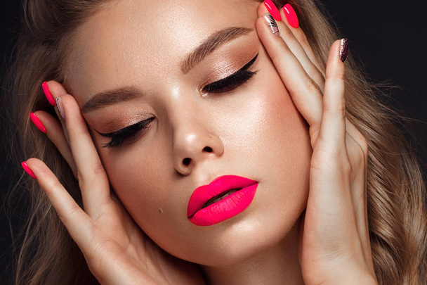 Beautiful young woman with bright makeup and neon pink nails. Beauty face. Photo taken in the studio - Photo, image