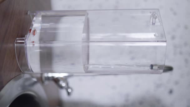 A konyhaszekrény vízzel feltöltött téglatest műanyag konténer. - Felvétel, videó