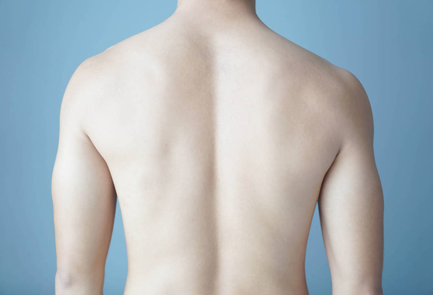 Back of man on blue background, beauty healthy skin care for men concept - Fotó, kép