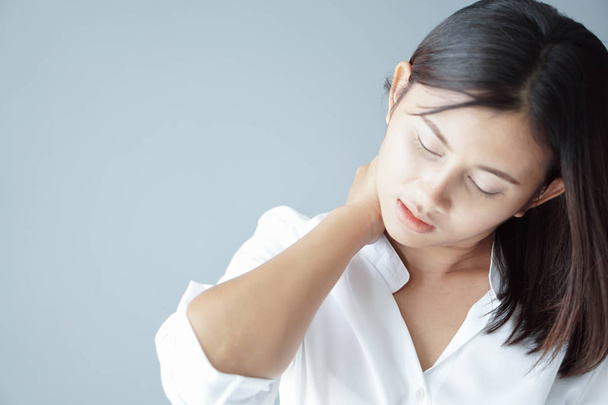 Primeros planos mujer sosteniendo el cuello con dolor después de despertar en la cama, cuidado saludable y concepto médico
 - Foto, imagen