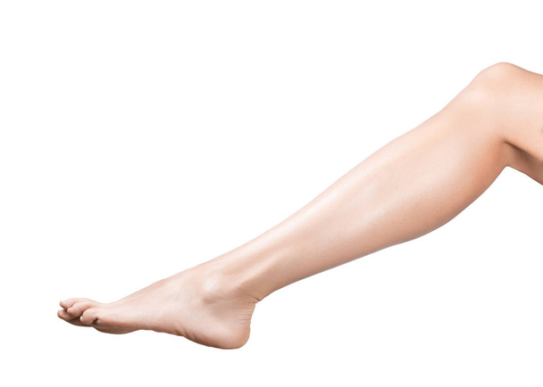 Female beautiful leg and bare foot with smooth skin, from sole to knee, ivory pedicure, isolated on white. - 写真・画像
