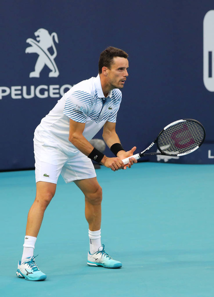 MIAMI GARDENS, FLORIDA - MARCH 27, 2019: Professional tennis player Roberto Bautista Agut of Spain in action during his quarter-final match at 2019 Miami Open at the Hard Rock Stadium in Miami Gardens - Photo, Image
