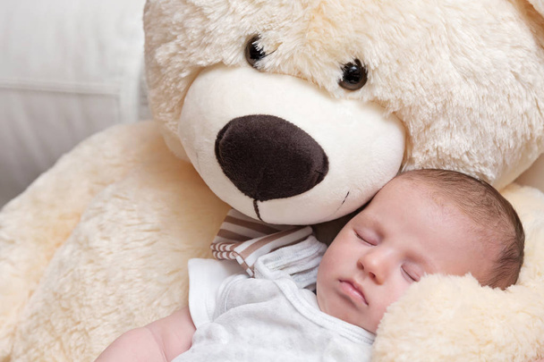 Bébé garçon dormant avec un gros ours en peluche
 - Photo, image