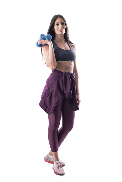 Zijaanzicht van fit actieve jonge Sportvrouw in sportkleding poseren en houden dumbbells. Volledige lichaam geïsoleerd op witte achtergrond.  - Foto, afbeelding