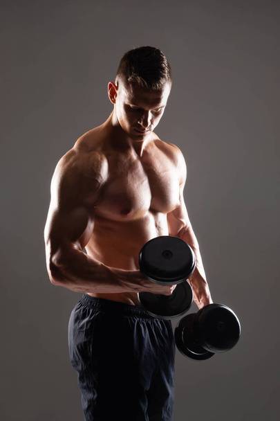 Strong, fit and sporty bodybuilder man over black background. Sport and fitness concept. - Fotografie, Obrázek