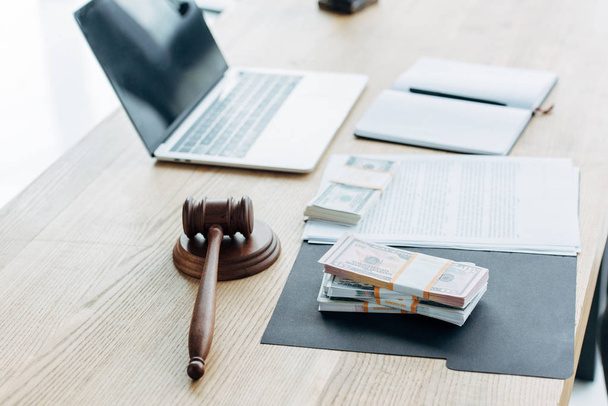selective focus of wooden gavel near money and laptop in office  - Foto, immagini