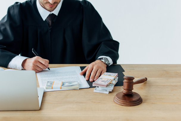 cropped view of judge holding pen near documents and wooden gavel on table  - Photo, Image