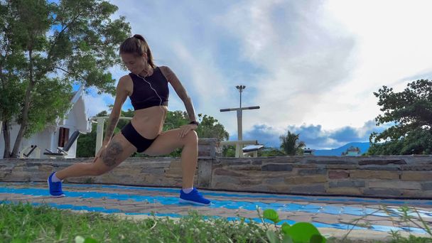  Fitness vrouw doet squats oefening outdoor - Foto, afbeelding