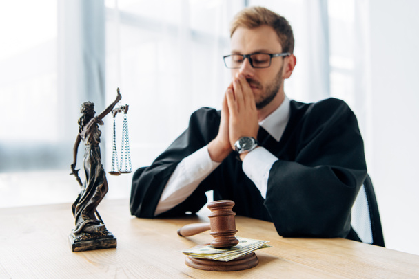 selective focus of wooden gavel with money near judge in glasses covering face  - Photo, Image