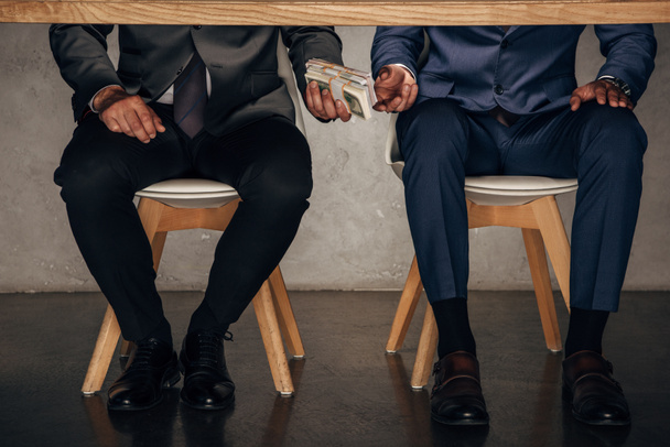 cropped view man giving cash to business partner while sitting on chair  - Photo, Image