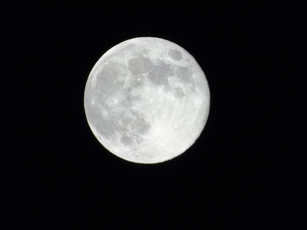 Luna llena aislada sobre fondo negro en días de verano
 - Foto, imagen
