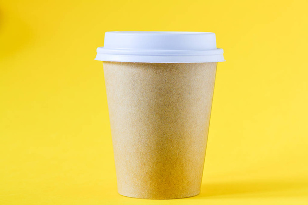 sarı arka plan gitmek için kahve ile kahverengi kağıt fincan yakın çekim görünümü - Fotoğraf, Görsel