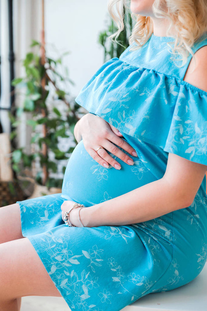 těhotná žena v modrých šatech jí nadula břicho - Fotografie, Obrázek