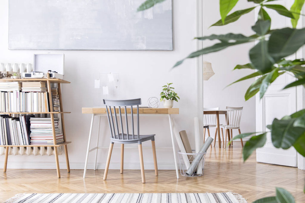 Stílusos skandináv lakberendezési a belső kreatív fa íróasztal, bambusz könyvárus tartozékokkal, könyvek és növények. Nyitott tér és nappali. A barna fa parketta és a stílusos szőnyeg. - Fotó, kép