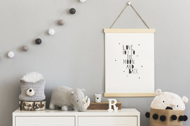 Stylish and cute scandinavian decor of child room with mock up poster, white shelf, natural toys, hanging cotton lamps, animal toy, basket for accessories and teddy bears. Bright and sunny interior. - Фото, изображение