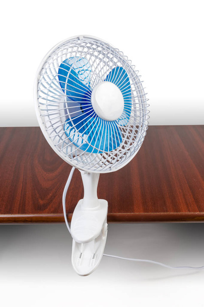 Moderne huishoudelijke elektrische klem Bureau ventilator bevestigd aan de tafel  - Foto, afbeelding
