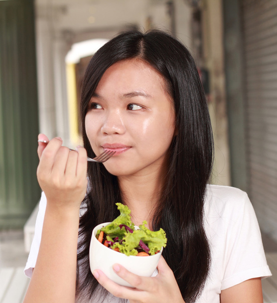 女性のレストランで野菜のサラダを食べる - 写真・画像