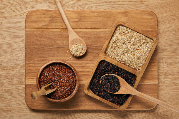top view of white, black and red quinoa on wooden chopping board - Photo, Image