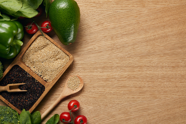 vue du dessus du quinoa blanc et noir dans des bols près de légumes mûrs et cuillère sur table en bois
 - Photo, image