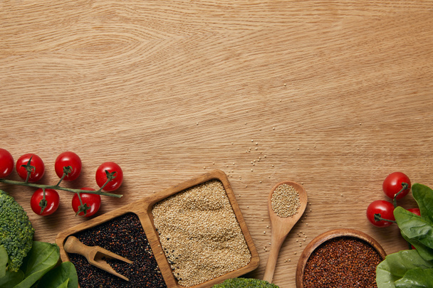 vue de dessus du quinoa blanc, noir et rouge dans des bols en bois près des tomates, des feuilles d'épinards et du brocoli
 - Photo, image