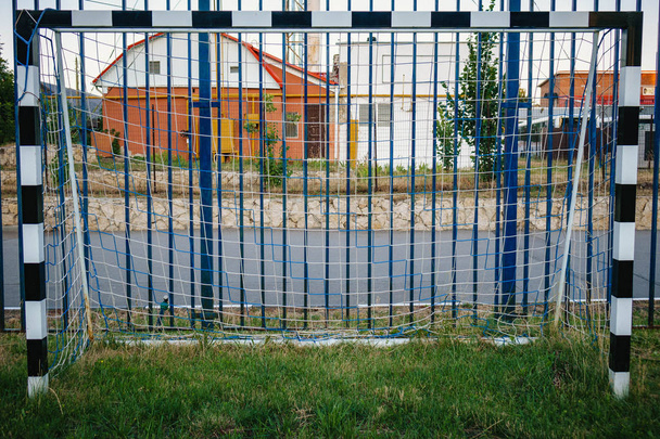 Γήπεδο ποδοσφαίρου με πράσινο γρασίδι ναυπηγείο και το ποδόσφαιρο γκολ στον σχολικό χώρο. το όμορφο άθλημα παιδική χαρά - Φωτογραφία, εικόνα