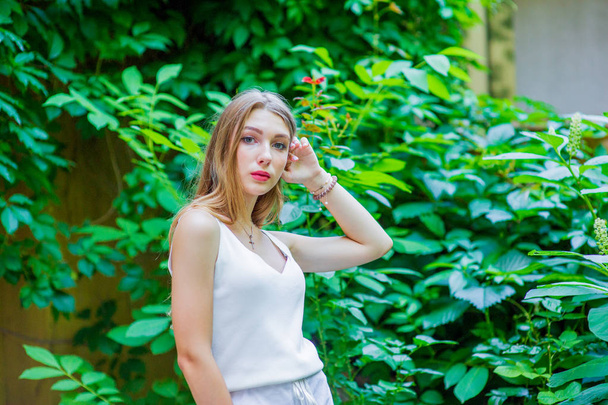 Menina bonita jovem posando ao ar livre, vestindo vestido branco na moda. Estilo de verão
. - Foto, Imagem