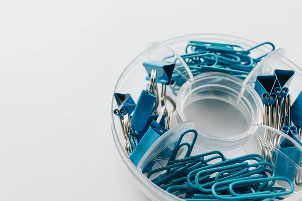 pile of blue paper clips in organiser on blue background - Photo, Image