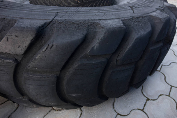 Nuevo neumático de goma con banda de rodadura para camiones y vehículos de ruedas de construcción especial para conducir en carreteras de asfalto y off-road, primer plano
. - Foto, imagen