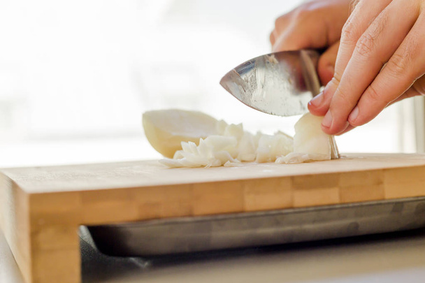 hands chopping onion in wooden board - Photo, Image
