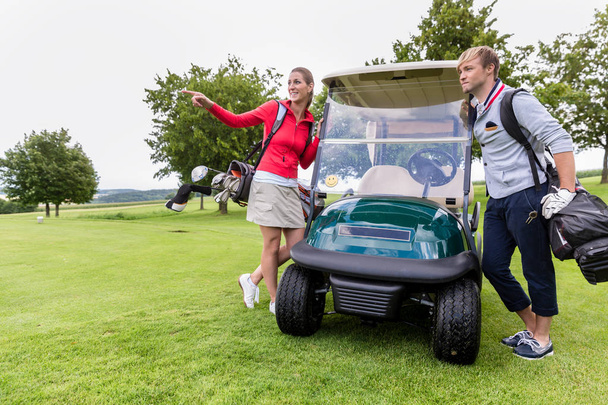 Пара стоящих возле гольф-кара
 - Фото, изображение