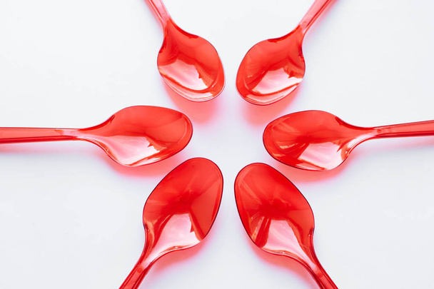 cucharas de plástico rojo plano sobre fondo blanco
 - Foto, Imagen