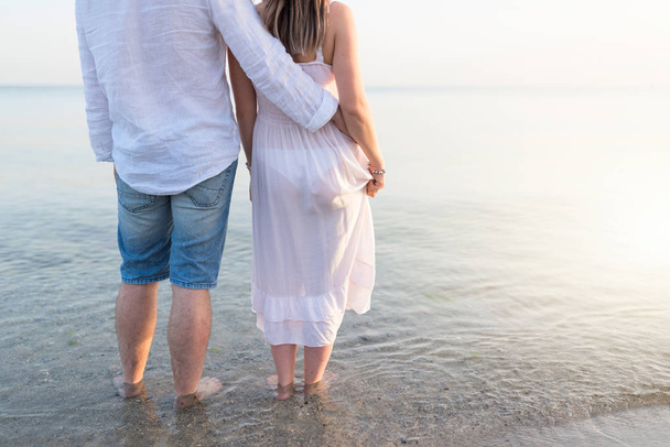 Letní dvojice, která se při západu slunce objímá na pláži. Romantický mladý pár si užívá slunce, sluníčko, romantiku a lásku k moři. Pár na letních prázdninách cestování dovolená - Fotografie, Obrázek