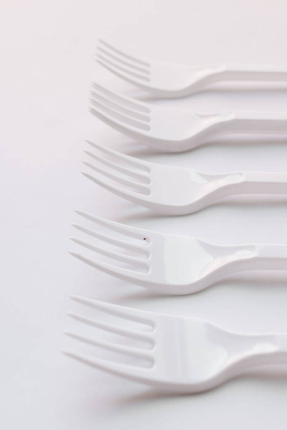 set of white plastic forks flat lay on white background - Foto, afbeelding