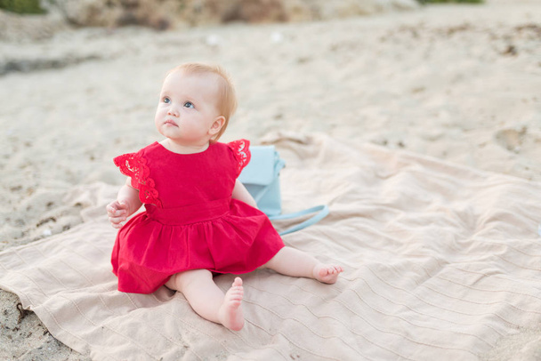 Beautiful little baby girl sitting on the beach - Photo, image