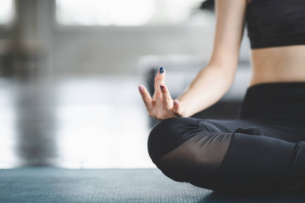 bijgesneden weergave van fitness Aziatische vrouw doen yoga oefening en ontspannen in sport Gym - Foto, afbeelding