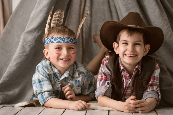 Boys as Indian and cowboy playing in her room - Foto, immagini